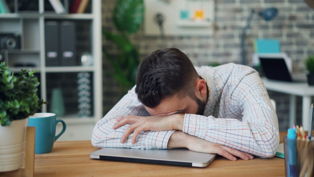Profissional emocionalmente esgotado em ambiente de trabalho tóxico.